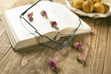 Old book, glasses, dry flowers on a wooden table. Village lifestyle