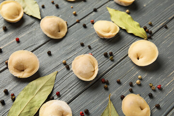 Raw dumplings on dark wooden background