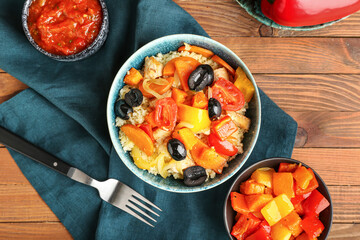 Bowl with couscous and vegetables on wooden background