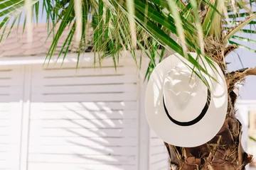 Rucksack Havana hat on palm tree. Summer mood at the resort. Tropical island, vacation by the ocean. Copy space.  © Stella
