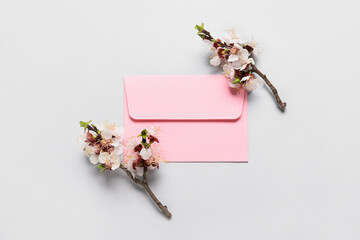 Beautiful blooming branches and envelope on light background