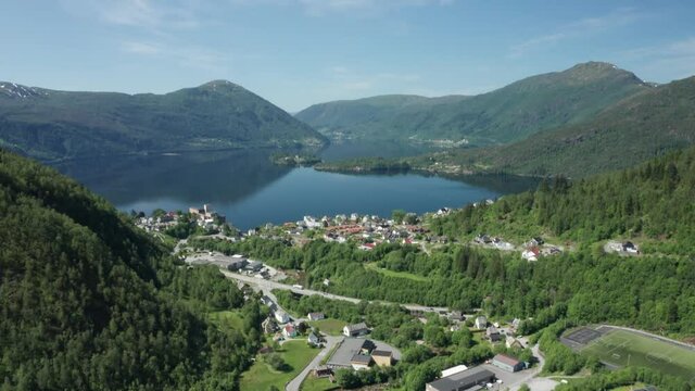 Tilt up from Tveitane Vaksdal showing overview of mountains, sea, osteroy and road E16