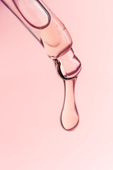 A drop of cosmetic oil falls from the pipette
