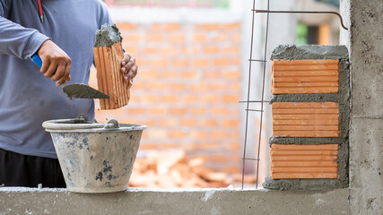 Close-up A skilled tiler hand will work the orange bricks to create the beautiful walls and designs closely.