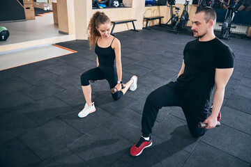 Two athletes working out with hand weights