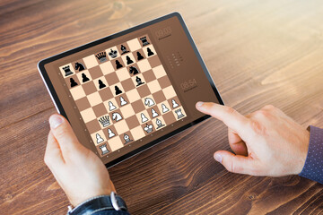 Man playing chess online on tablet computer