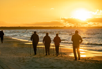 Active and healthy lifestyle. Nordic walking on a sandy beach sea shore