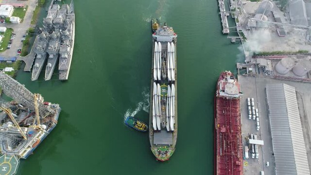 Barco transportando torres e&oacute;licas sobre un r&iacute;o