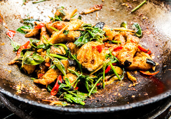 Frying chopped catfish with herbs and vegetable in pan , in door  Chiangmai  Thailand.