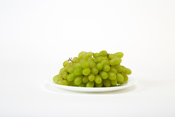 ripe green grapes on a white plate