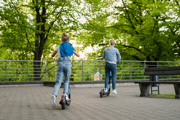 Mother and daughter riding electric scooters