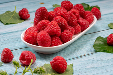 Raspberry fruit on blue Wooden background, Raspberries with leaves on Wooden background.
