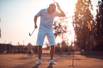 Senior man playing golf.