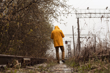 Yellow cloak, forest. A man in a yellow raincoat, cold and wet weather.