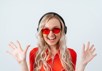 Portrait of young pretty surprised woman with open mouth, standing with open palms, happy blonde girl in red glasses.