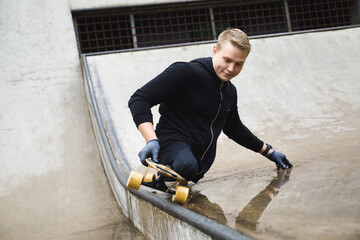 Young handicapped guy with a longboard in a skatepark