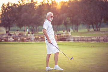 Senior man playing golf alone.