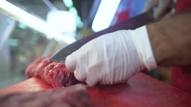 Butcher cuts fresh raw meat at the butchery