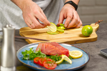 Cooking with notebook tuna steak in home kitchen. Online cooking recipe concept, fish cooking at home. lifestyle, healthy eating, cooking and dieting concept.