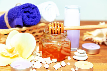 Golden honey jar, orchid flowers, towels and aromatic candles.