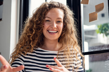 Close up shot of happy smiling Caucasian woman talking while making video call conference at home