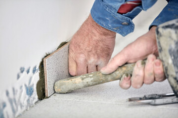 Ceramics tile man worker placing new tiles on the floor and wall.