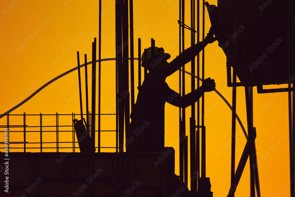 Wall mural Real construction worker working on a high building.