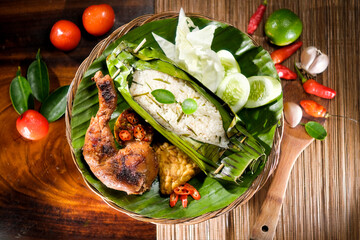 Indonesian Grilled Rice wrapped in banana leaves served with spicy grilled chicken - 430318989