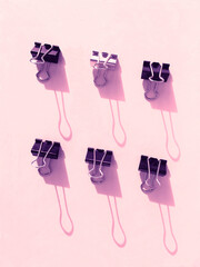 Stationery metal clips on pink background
