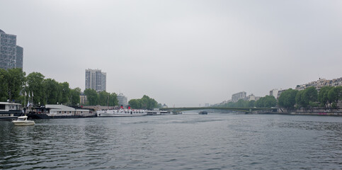 Fototapeta na wymiar View of the Mirabeau Bridge. On the river Seine ships sail, some moored in the port