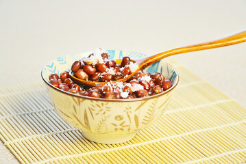 A bowl of nutritious and healthy red bean porridge with sugar, a wooden spoon