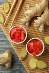 Concept of tasty eating with pickled ginger and chopsticks on wooden table