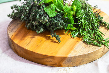 Medicinal plant Rosemary, mint and  thyme bunch on wooden board for home remedies and natural...