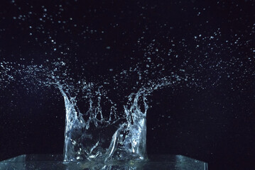 The clear water is splashing around, like a crown. Black background