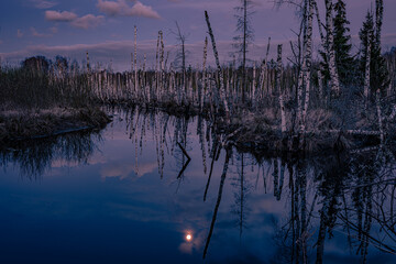 Night moon in the sky and reflection on the river