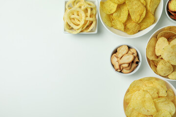 Bowls with different snacks on white background