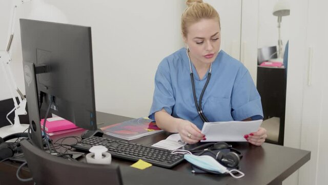 Female doctor reading papers in office