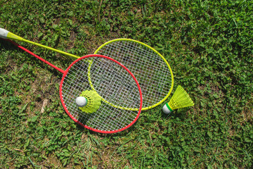 Bagminton rockets and ball in the green grass park in the spring
