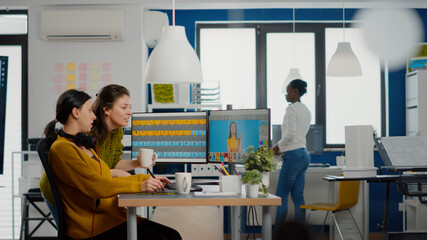 Art director consulting designer colleague, retouching portrait in photo editing software working...