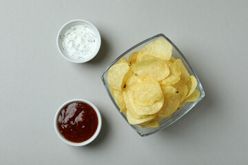 Bowl of chips and sauces on light gray background
