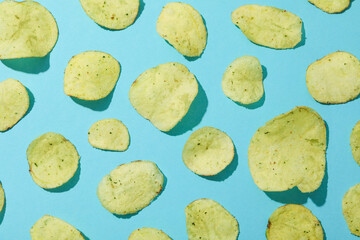 Potato chips on blue background, top view