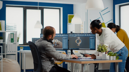 Professional heavy industry team of engineers working on computer with two monitors using CAD...