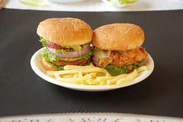 Chicken and beef hamburgers in white plate, black background