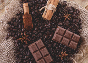 chocolate, coffee beans, anise and cinnamon on wooden background