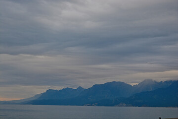 clouds over the mountains with grey sea in cloudy day