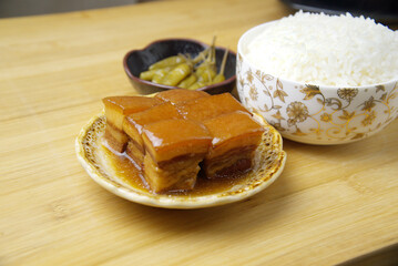 Fat but not greasy braised pork, sour chili and rice. Delicious lunch on bamboo cutting board