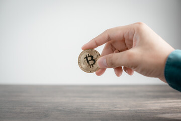 Hand holding golden Bitcoin cryptocurrency coin. investment concept