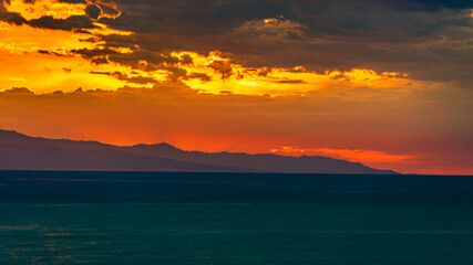Abstract sunrise sky over the sea. Teal, yellow and orange concept, copy space, background 