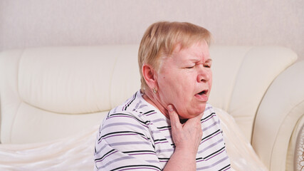 Elderly woman on bed with sore throat