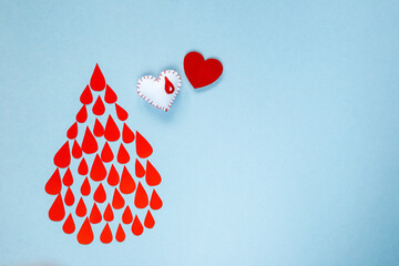 many drops of blood in the form of a drop on a blue background, world blood donor day, charity and...